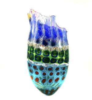 a tall open glass vessel with a ruffled and uneven top edge. Multi colora and patterns are arranged in layers.