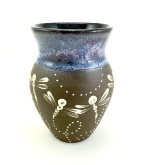 A brown ceramic vase with an ocean blue glazed lip with hand drawn illustrated dragonfly pattern on the center and lower portion.