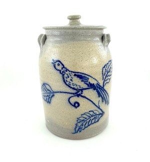 LIdded ceramic vessel with compact side grasp handles. Glaze is light grey with hand illustrated bird on a branch decoration in cobalt blue.