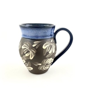 A brown tone ceramic mug with an ample arching handle with a sky blue rim and a decorative illustration of chrysanthemums in white.
