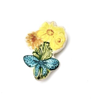Handformed ceramic pin in the shape of a bouquet of flowers with a blue ribbon tied around the stems.