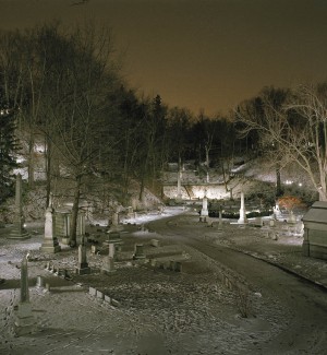 color photograph of nighttime landscape of stone grave stones and mortuaries.