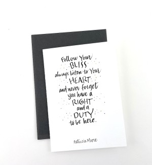 White paper greeting card with calligraphy 'Follow Your BLISS always listen to Your HEART and never forget you have a RIGHT and a DUTY to be here' on cover. Dark grey envelope.