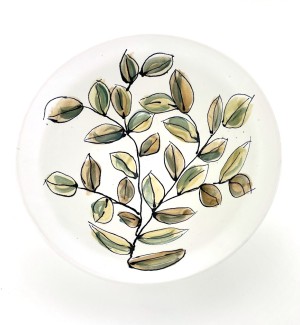 White ceramic hand painted bowl with green and yellow leaf and branch pattern.