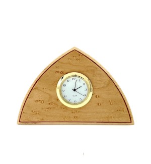 a small triangular wood clock with a birdseye maple veneer and round brass ringed clock face.