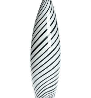 a tall and narrow glass vessel form withj alternating black and white stripes wrapping around the form like a barber pole.