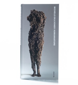 a book cover with a standing armless human body-like sculpture with an organic texture throughout in front of a neutral background and the title 'HumanNature'.