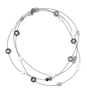 a necklace of a long thin cable that is strung randomly with beads in variety of shape and color and materials from clay to white pearls to faceted glass.