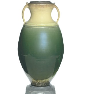 a tall and narrow ceramic vase with a glaze that blends from celedon green to ivory. 