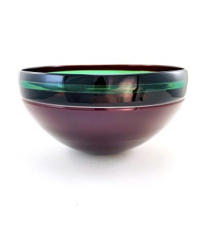 a glass bowl with a smooth surface and dark purple base, black band around the rim with a bright green accent stripe.