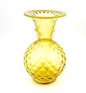 A yellow glass vase, the vase has an inverted cone shaped top and a spherical bottom and an optical texture.