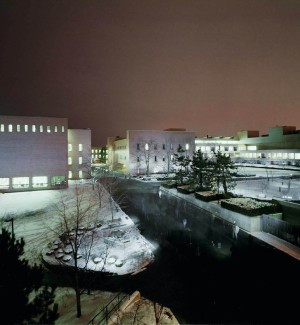 a color photograph of a nightime  view of multiple buildings with walkways.