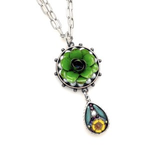drop pendant made from a curation of artisan beads, pearls and a green enamel flower set in resin and metal strung on a double link metal chain.