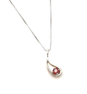 a silver teardrop shaped pendant with a red gem.