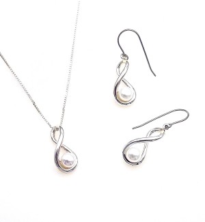 A pair of silver earrings shaped like infinity symbols with a pearl perched in the center placed next to a necklace with the same infinity design.