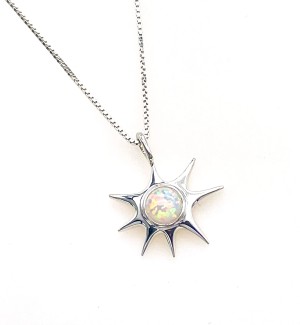 a silver pendant in the shape of a star with a white stone in the center.
