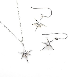 A pair of silver star earrings with 6 points, pictured next to a necklace of the same design.