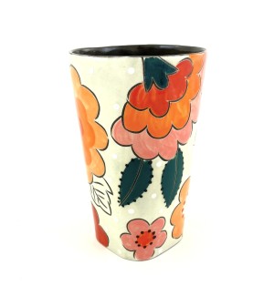 a ceramic tumbler with a white background and ilustrated colorful flowers.