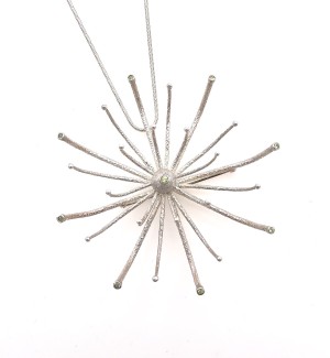 a pendant/brooch of sterling that resembles a large firework chrysanthemum burst with green gems at the points.