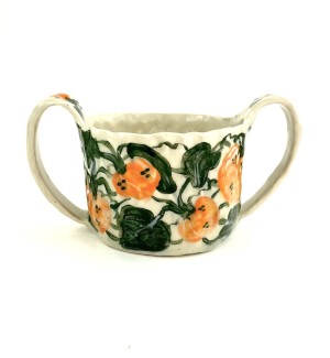 a hand formed ceramic bowl with two handles and hand illustarted orange pumpkins and green vines.