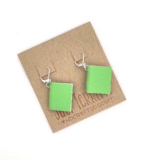 A pair of earrings with small, functional lime colored books. 