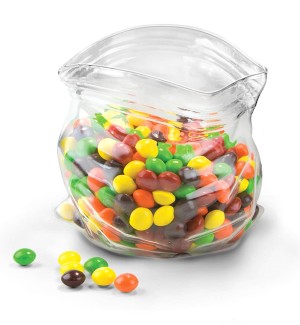 a clear glass vessel that resembles a crumpled plastic bag filled with colorful m&M candy.