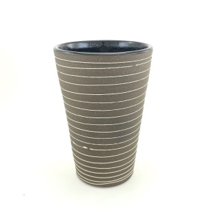 a ceramic tumbler with a dark grey clay body and delicate horizintal white lines encircling the perimeter.
