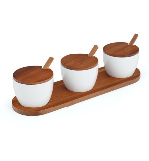 three white ceramic bowls with a wood lid and small wood spoon arranged on an oval wood tray.