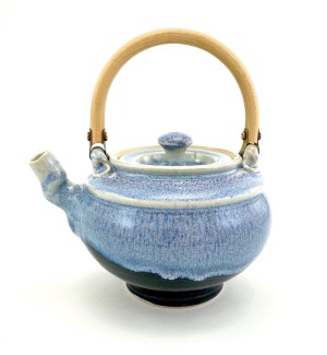 a ceramic teapot with a sky blue glaze and a bamboo arched handle.