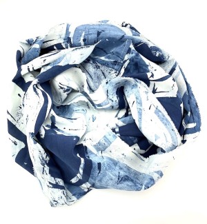 a silk scarf with a blotchy pattern in white and navy blue arranged in a donut shape. 