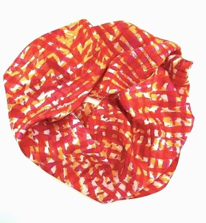 a silk fabric scarf with striations of red, yellow and orange arranged in a circle.