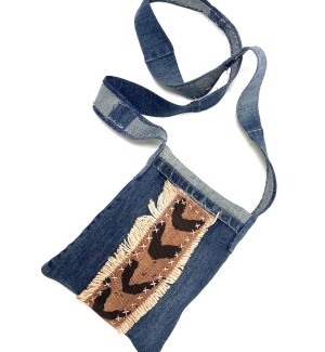 a handsewn blue jean fabric shoulder bag with strips of brown and black chevron patterned African mudcloth..