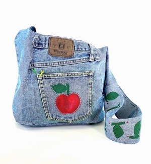 a handsewn blue jean fabric shoulder bag with a hand painted red apple and green leaf. 