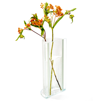 a clear glass vase with a ribbed textural round half and a flat side with orange flowers.