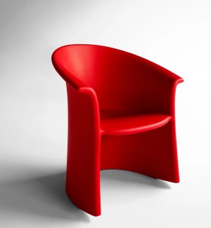 thre quater view of a bright red solid shaped rocking chair. 