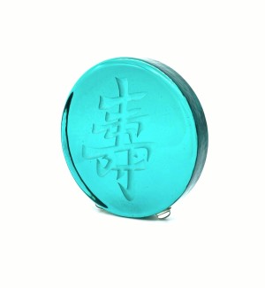 a round green glass disk with a sand blasted Chinese character 'Longevity, Long Life'.  