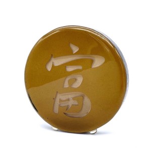 a bronze hued round glass disc with the Chinese charater 'Prosperity, Abundance'. 