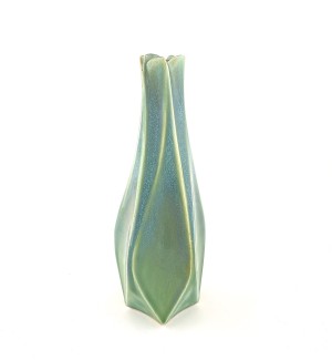 a faceted green ceramic vase with a body twist and floral shaped mouth.