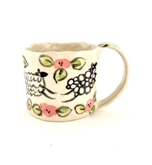 a hand formed textured porelain mug with illustrations of sheep and pink flowers.
