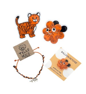 a set of items, two vinyl stickers and an acrylic pin with a cartoonish tiger illustration, and a hand knotted tiger charm bracelet.