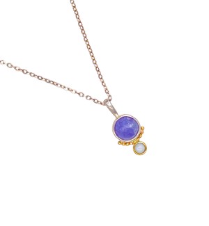 a pendant with a lavender-hued, faceted tanzanite stone is bezel set in Sterling. Accentuated with a series of 14k gold beads and an opal bezel set in gold.