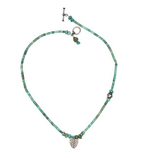 a strung bead necklace of tubular turquoise beads and small silver beads with a toggle clasp.