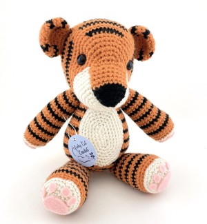 a stuffed black-striped orange tiger made from crocheted yarn with button eyes.