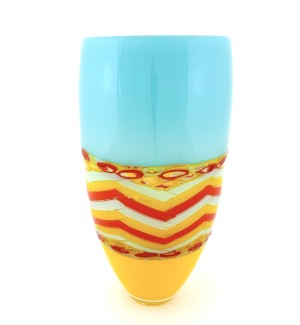 a tall, narrow glass vase with a turquoise top band, a red and yellow chevron colored central band and a yellow base. 