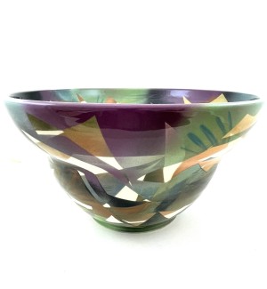 a handthrowm ceramic bowl with an open and wide lip decorated with angular patches of purple, green, blue and gold. 