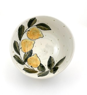 a white ceramic bowl with three hand illustrated yellow lemons with green leaves.