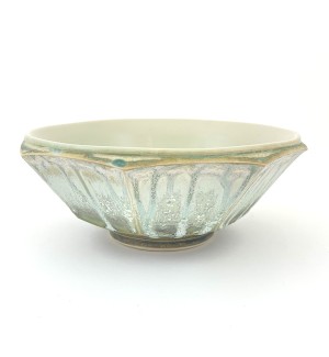 a round celadon green glazed bowl with a smooth interior and faceted exterior with drips in the glaze.