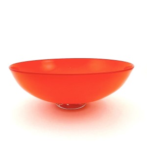a handblown glass bowl with a low sleek profile, a clear glass foot and an opaque bright orange bowl with a red line at the lip.