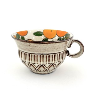 a ceramic mug in the shape of a bowl illustrated interior of oranges and a beige quilted surface exterior.