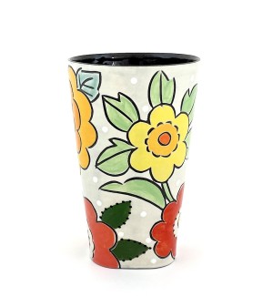 a ceramic tumbler with a white base and illustration of a bouquet of yellow, orange and red flowers.